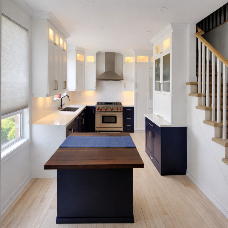 Modern kitchen renovation with white cabinets, navy blue island, butcher block countertop, and stainless steel range.