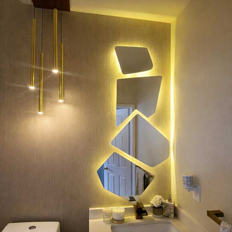 Modern powder room vanity with geometric LED backlit mirrors and gold pendant lights.